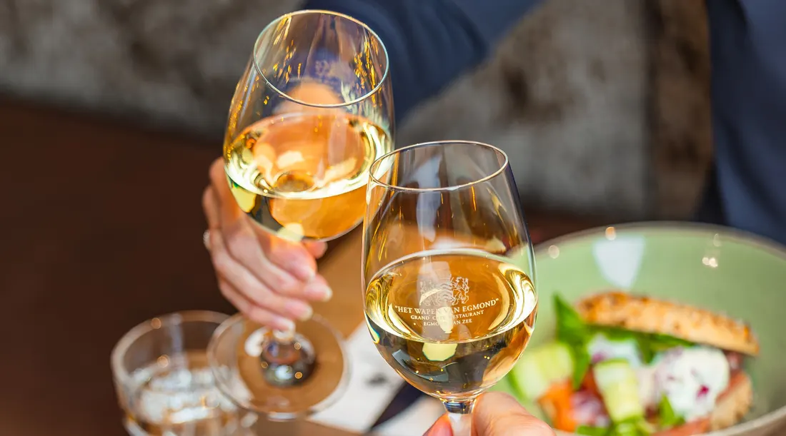 Gasten proosten met witte wijn