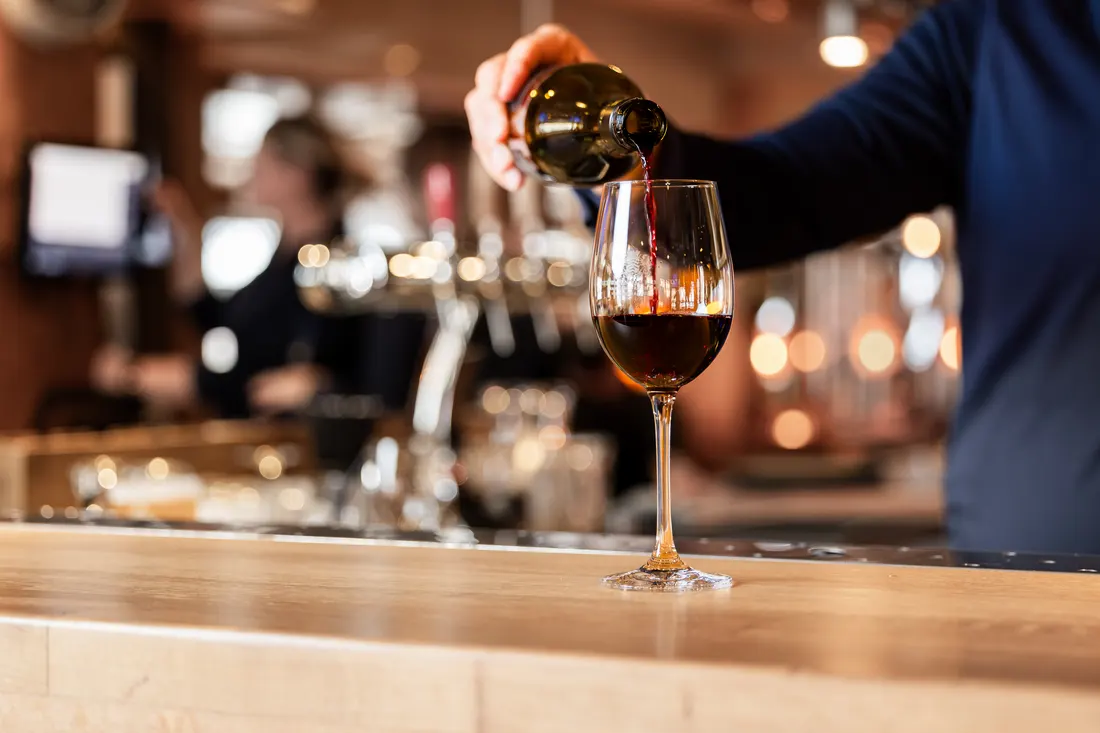 Rode wijn wordt ingeschonken aan de bar